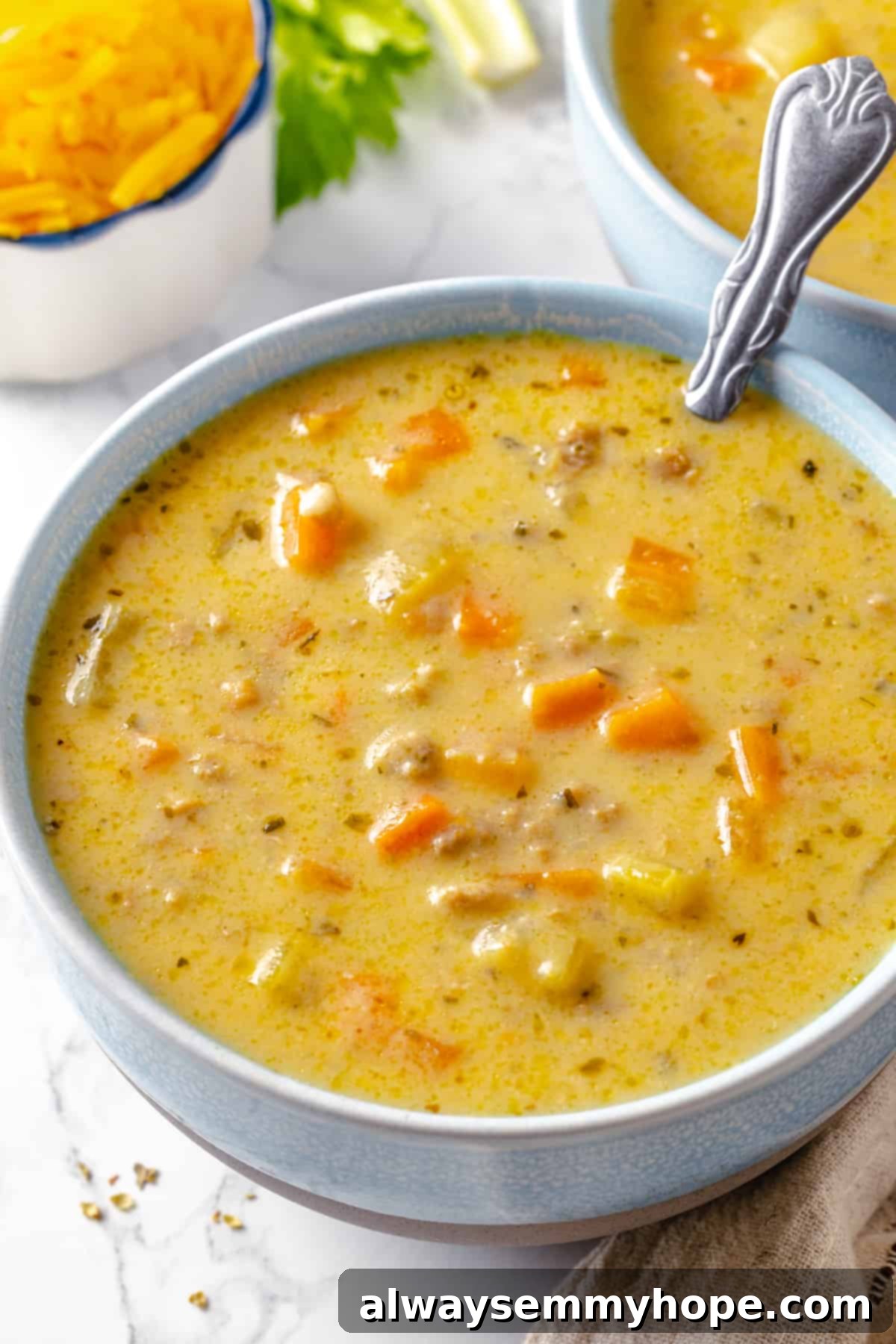 Hearty vegan cheeseburger soup is the ultimate comfort food meal, brimming with savory plant-based flavor and cheesy goodness. It’s like a burger in a bowl! Vegan cheeseburger soup in bowl, garnished with herbs