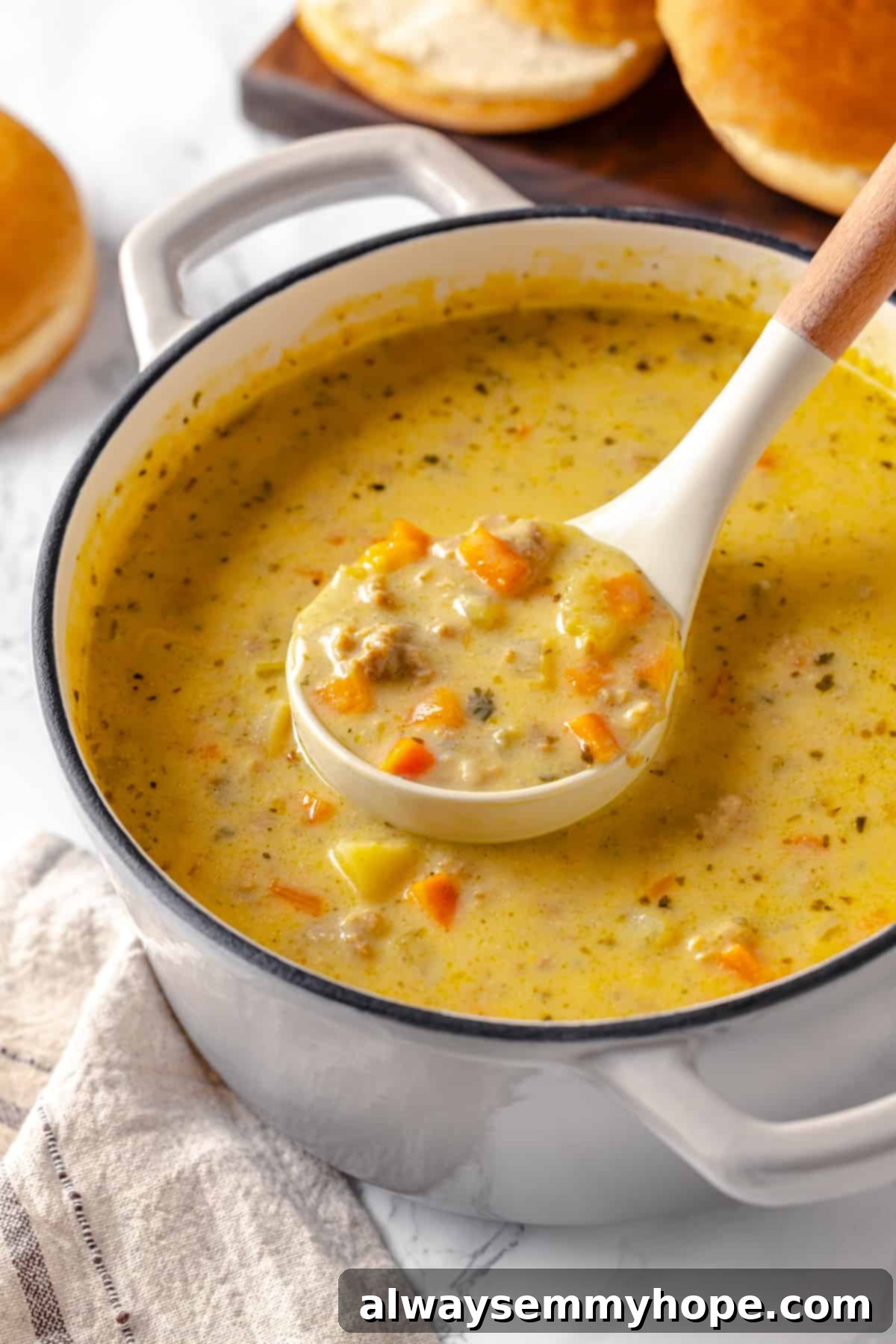 Hearty vegan cheeseburger soup is the ultimate comfort food meal, brimming with savory plant-based flavor and cheesy goodness. It’s like a burger in a bowl! Ladle of creamy vegan cheeseburger soup in a pot, ready to serve