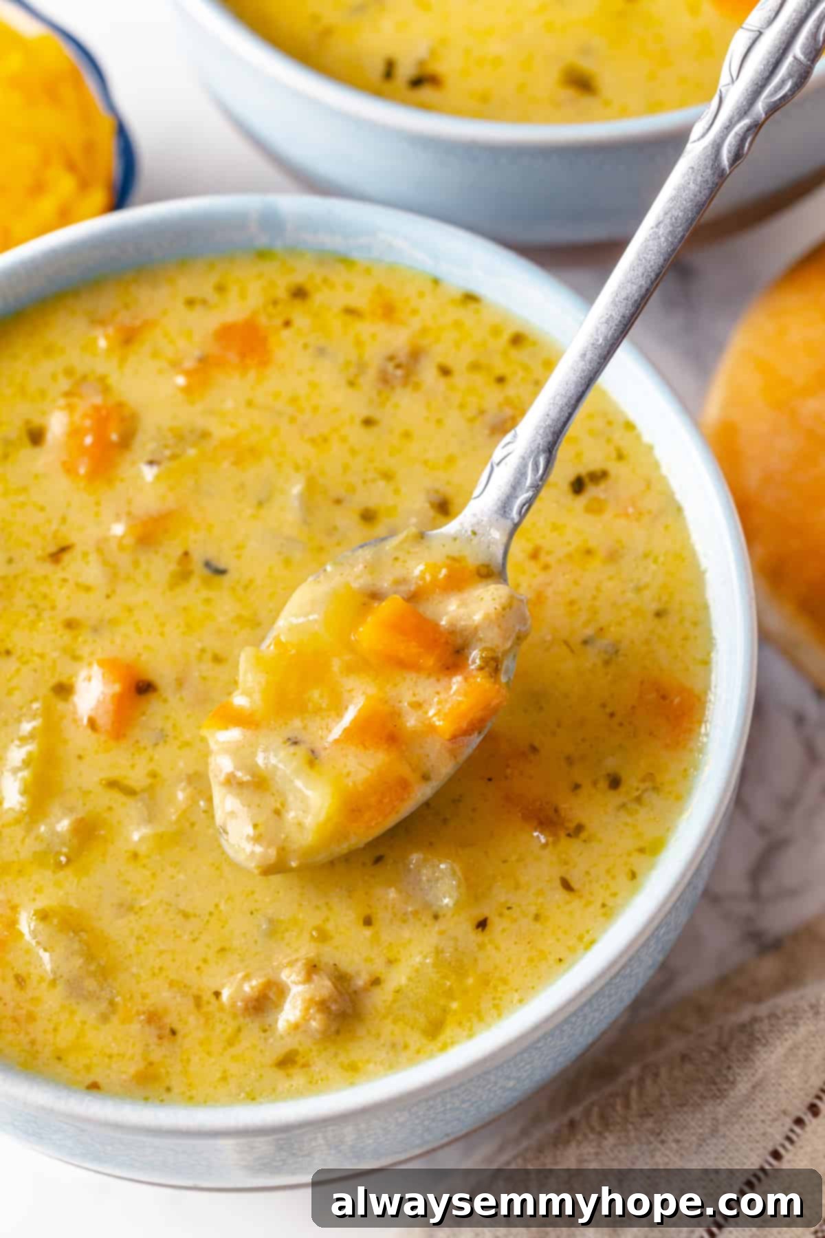 Hearty vegan cheeseburger soup is the ultimate comfort food meal, brimming with savory plant-based flavor and cheesy goodness. It’s like a burger in a bowl! Spoonful of creamy vegan cheeseburger soup in a bowl with a sprinkle of fresh herbs