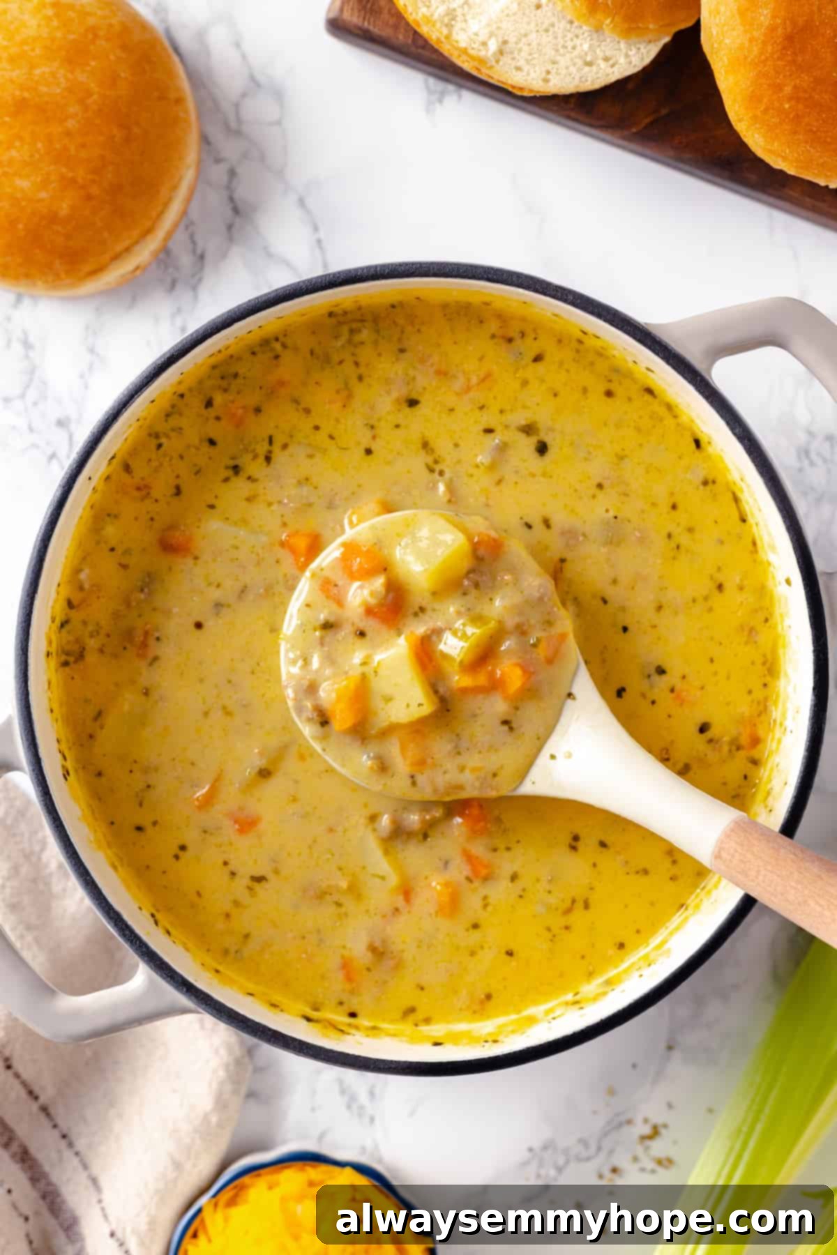 Hearty vegan cheeseburger soup is the ultimate comfort food meal, brimming with savory plant-based flavor and cheesy goodness. It’s like a burger in a bowl! Ladle full of creamy vegan cheeseburger soup held over a large pot