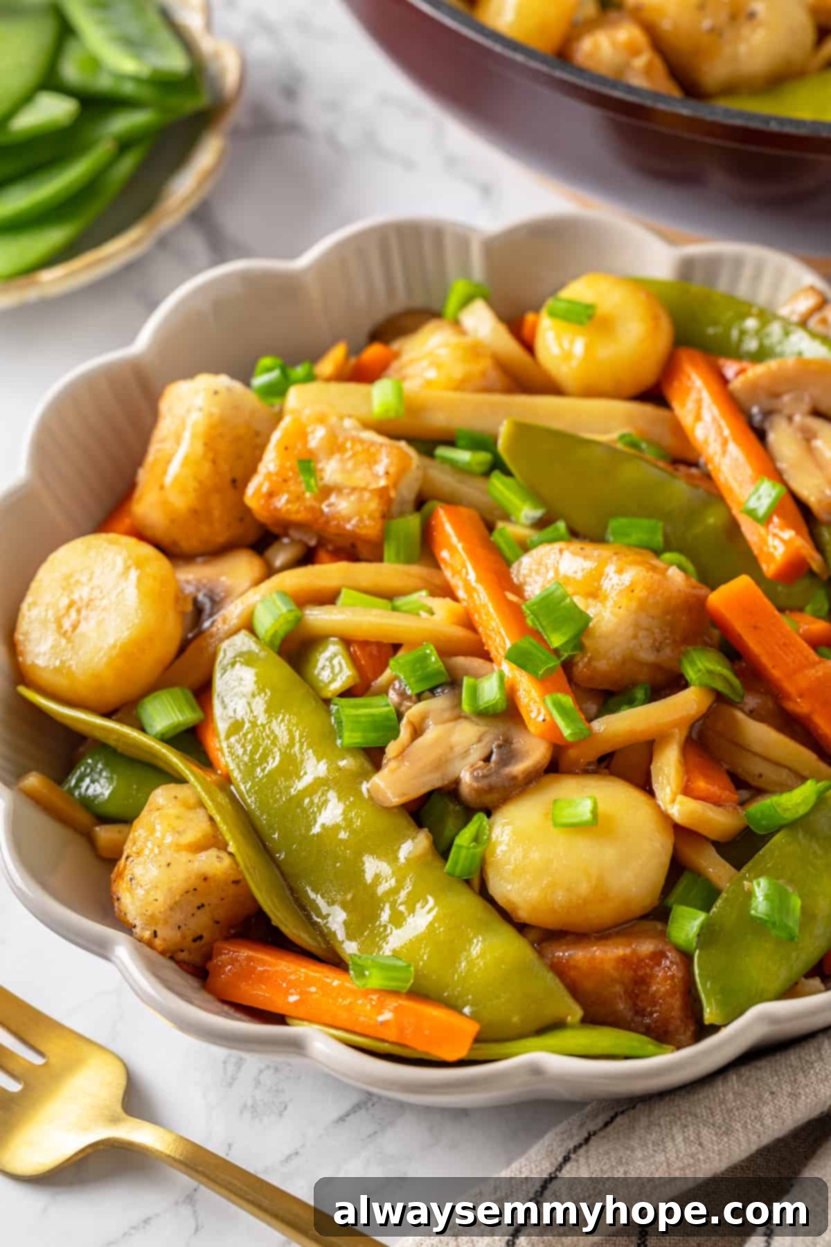 Close-up of a bowl of vegan tofu moo goo gai pan, perfectly plated