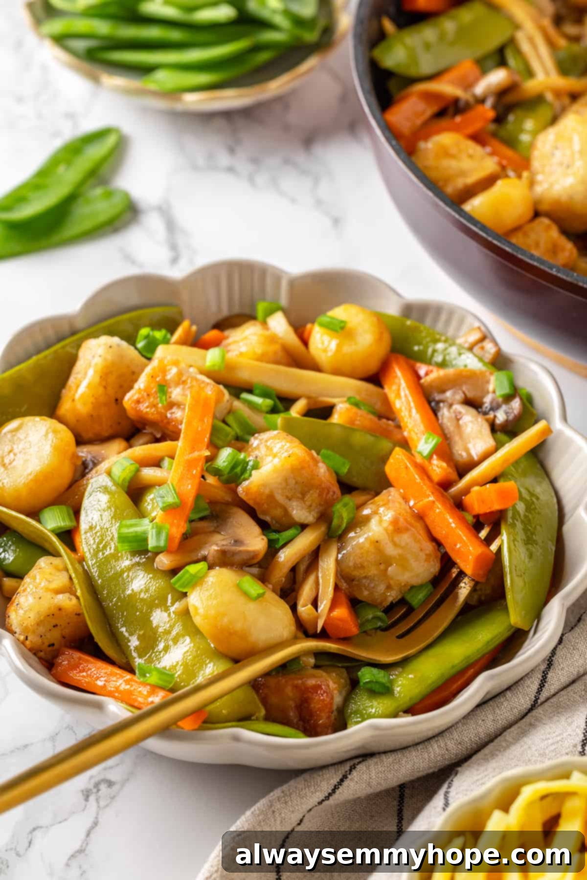 Vegan moo goo gai pan in a bowl with a fork, ready to be eaten