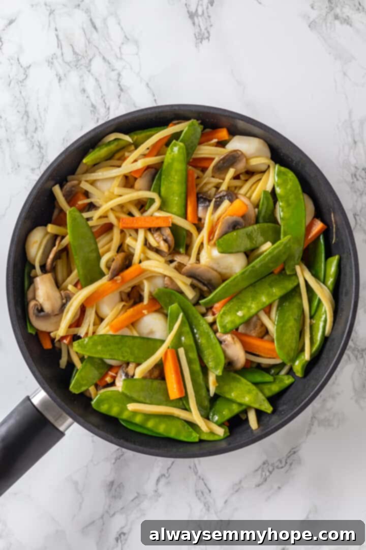 Skillet of moo goo gai pan with tofu and vegetables mixed in the sauce