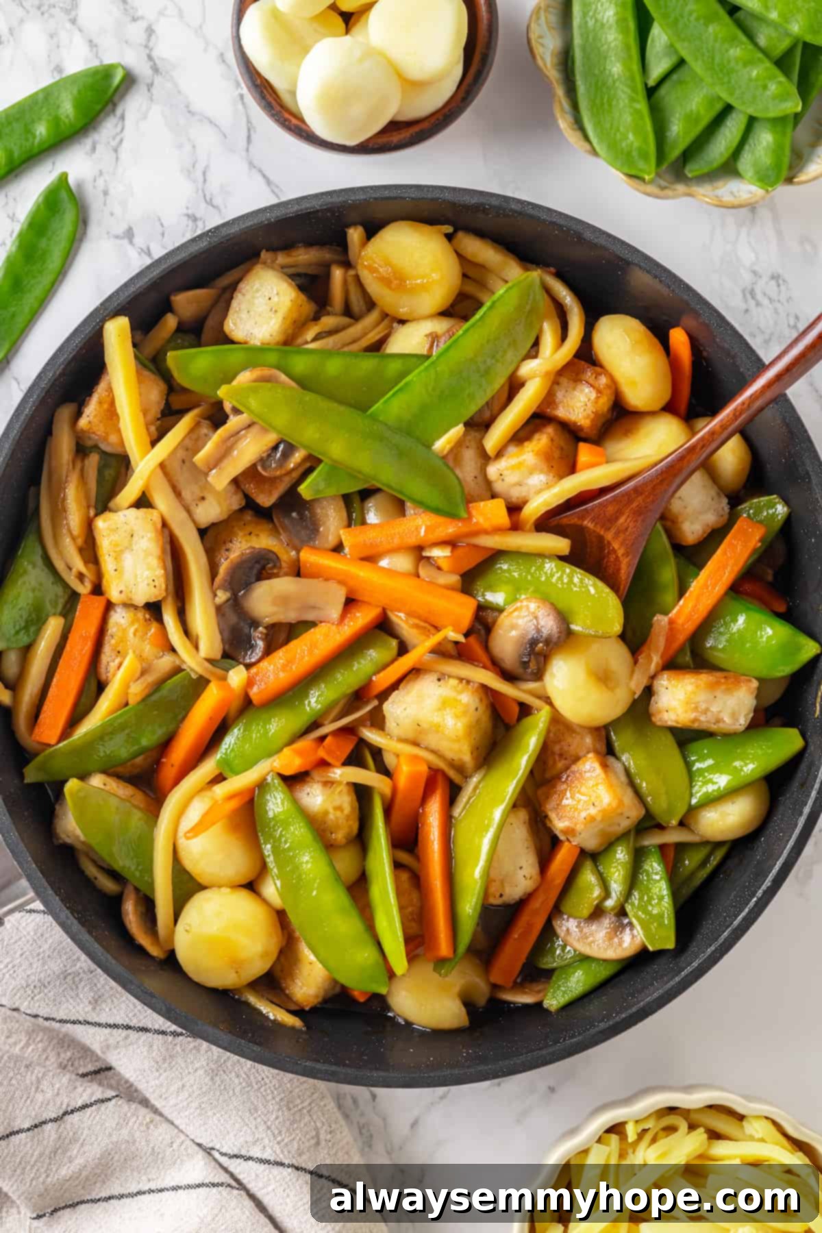 Overhead view of finished tofu moo goo gai pan in a large skillet, ready to serve