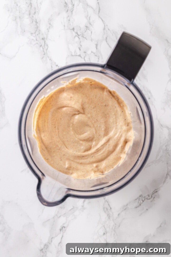 Blend vegan sour cream, cream cheese, taco seasoning, chili in adobo, and nutritional yeast for the smooth and creamy taco dip base. Step-by-step: All creamy vegan taco dip base ingredients in a blender, ready to be processed