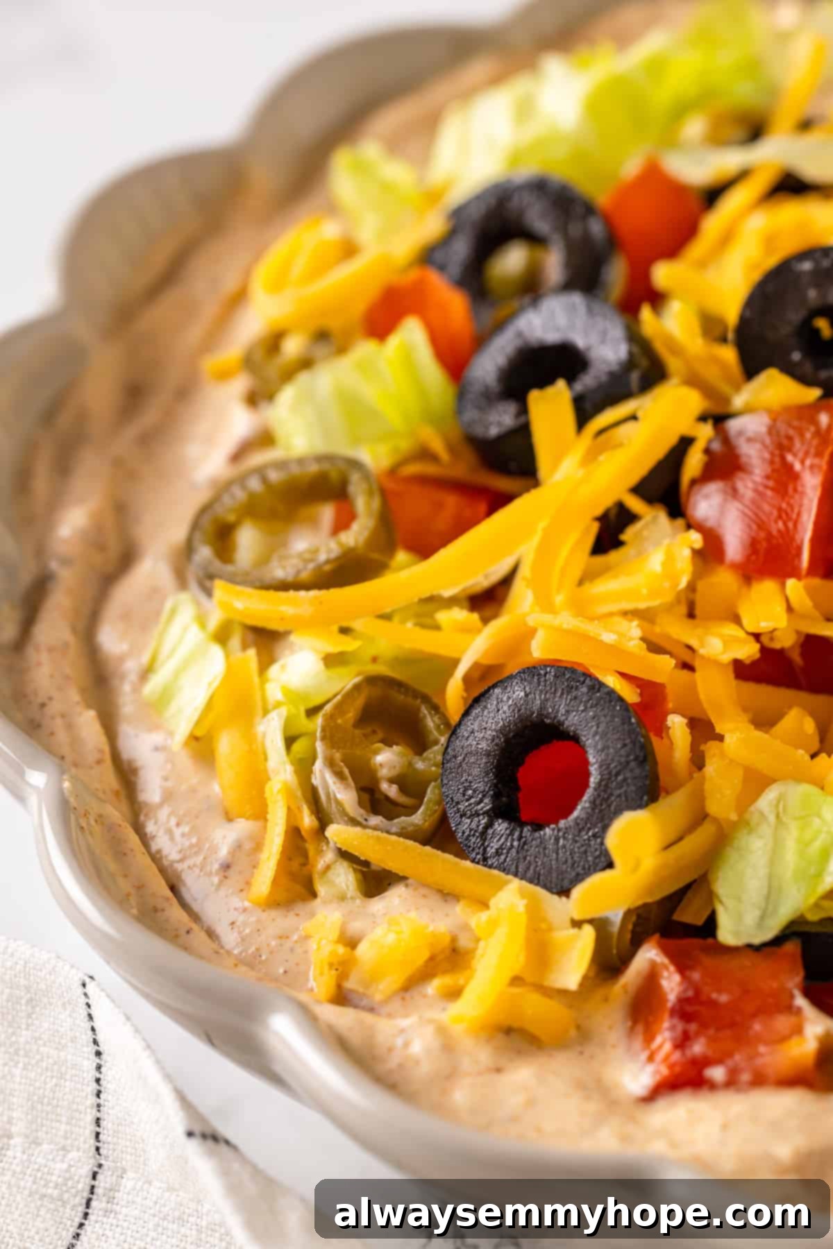 A mouth-watering closeup of the easy vegan taco dip, highlighting its creamy texture and fresh, vibrant toppings, ready to be enjoyed. Close-up shot of a vibrant vegan taco dip with all toppings, ready for serving at a party