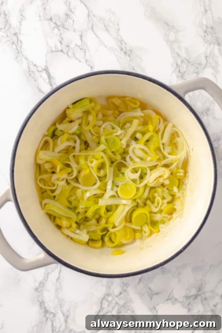 Sautéing leeks and onions for vegan vichyssoise Overhead shot of sliced leeks and diced onions sautéing in vegan butter in a large pot