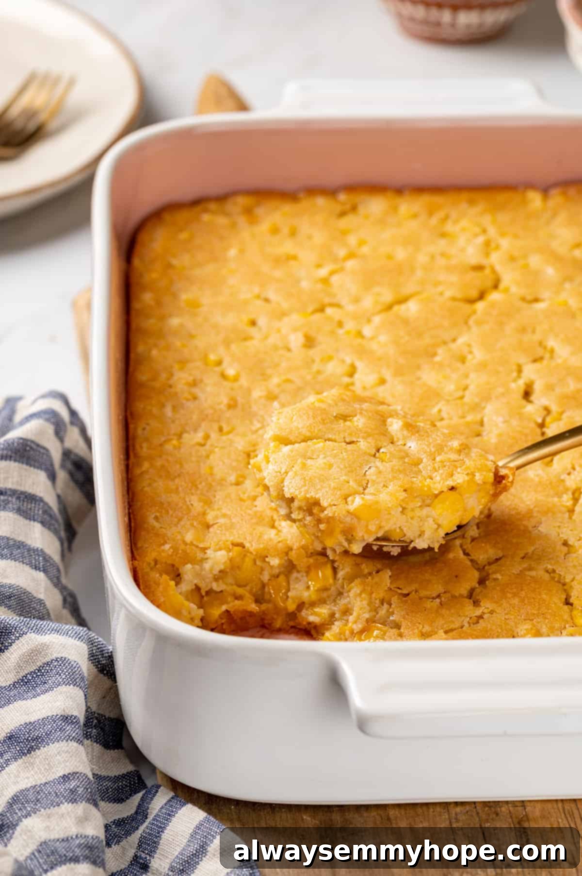 Corn soufflé is a classic holiday side dish, but easy enough to make for a weeknight! You’ll love the sweet flavour and creamy texture. Close-up of fluffy vegan corn soufflé in a baking dish, ready to be scooped