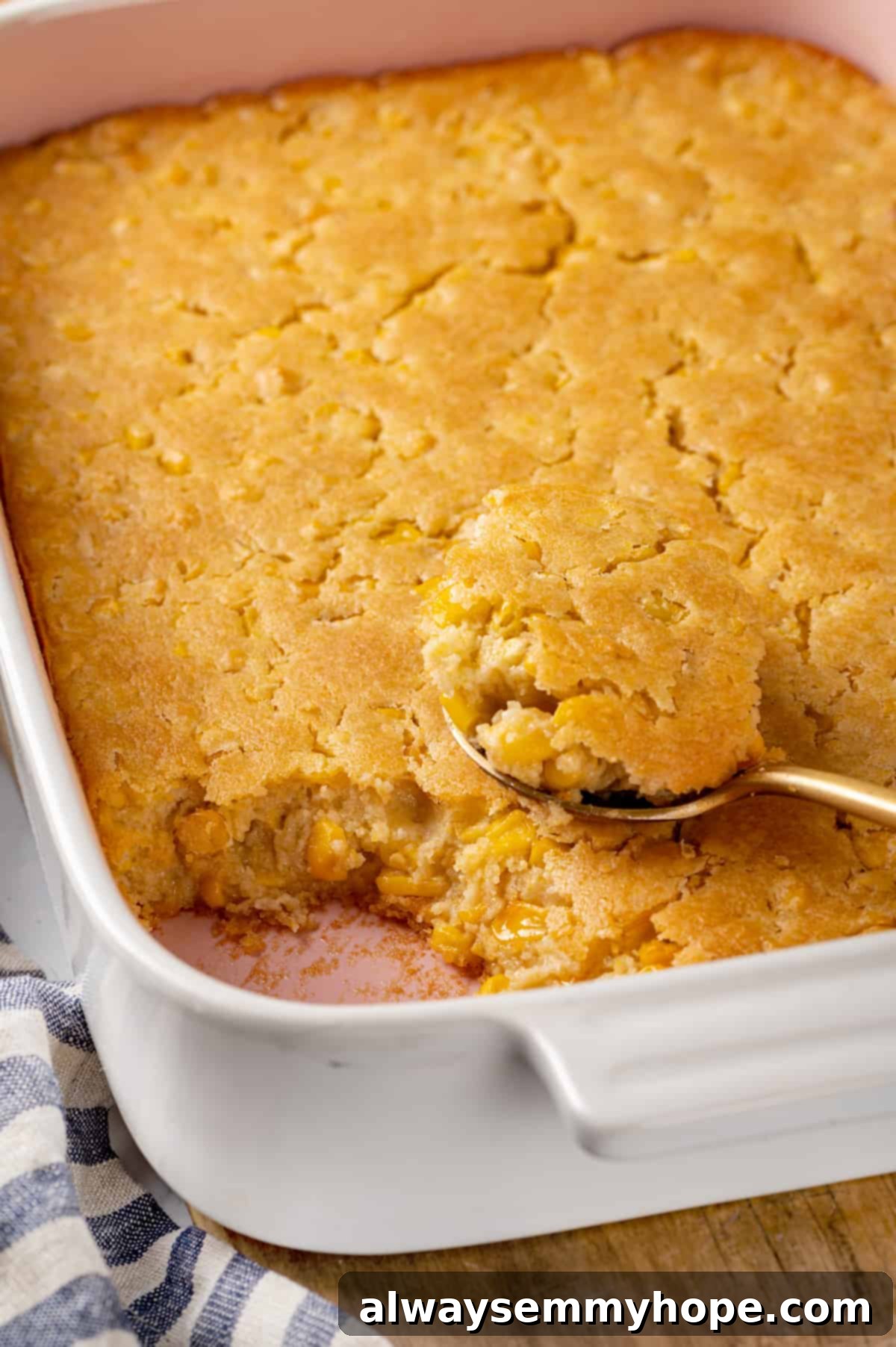 Corn soufflé is a classic holiday side dish, but easy enough to make for a weeknight! You’ll love the sweet flavour and creamy texture. A serving spoon lifting a portion of warm vegan corn soufflé from the baking dish