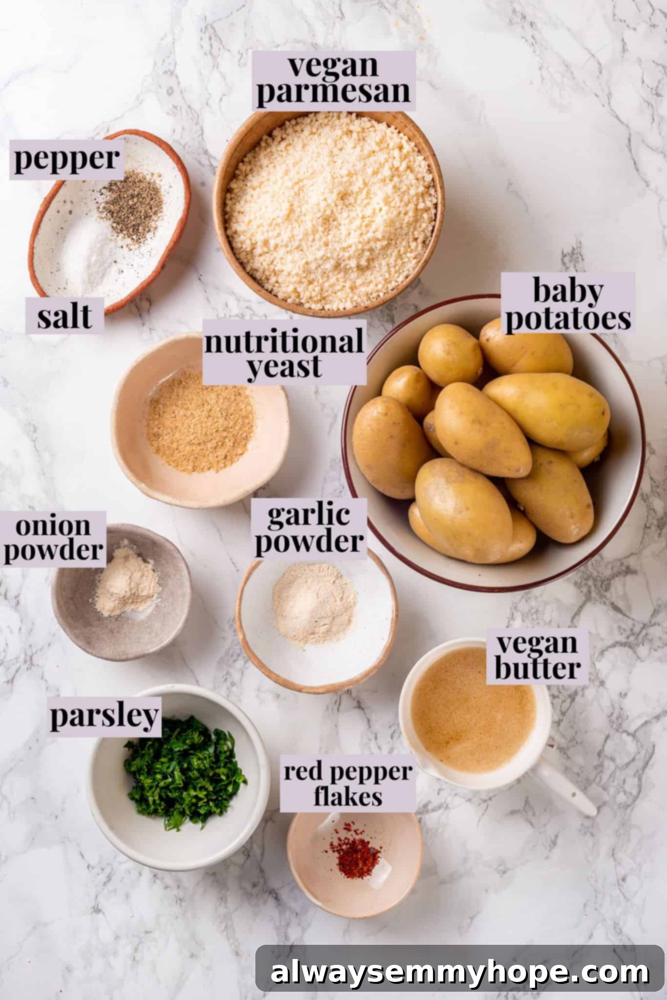 All the fresh ingredients laid out for making vegan Parmesan crusted potatoes. Overhead view of ingredients for vegan Parmesan crusted potatoes with labels