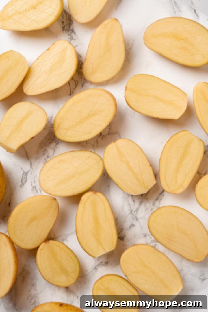 Halved baby potatoes arranged on a cutting board. Overhead view of halved baby potatoes, ready for scoring