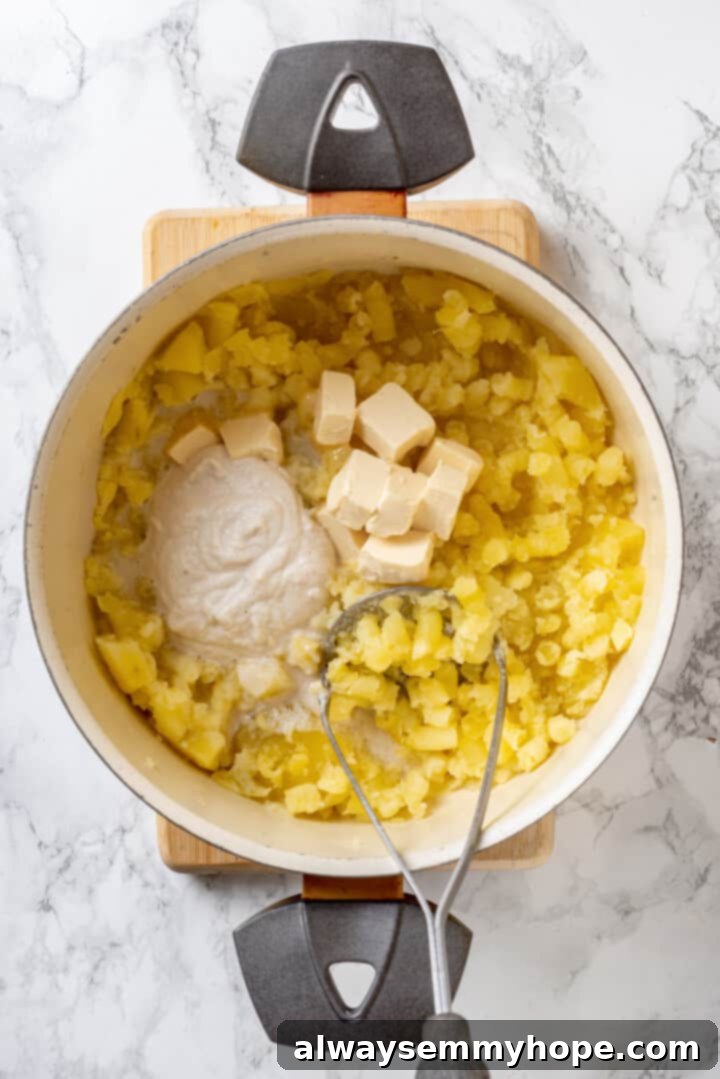 Overhead view of vegan butter and sour cream added to mashed potatoes