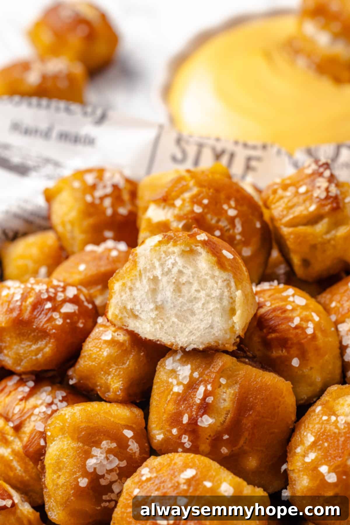 Homemade vegan pretzel bites are the snackable sibling to regular soft pretzels! They're perfect for game day parties and easy to make too. A close-up view of a sliced pretzel bite, revealing its soft, airy, and fluffy interior texture.