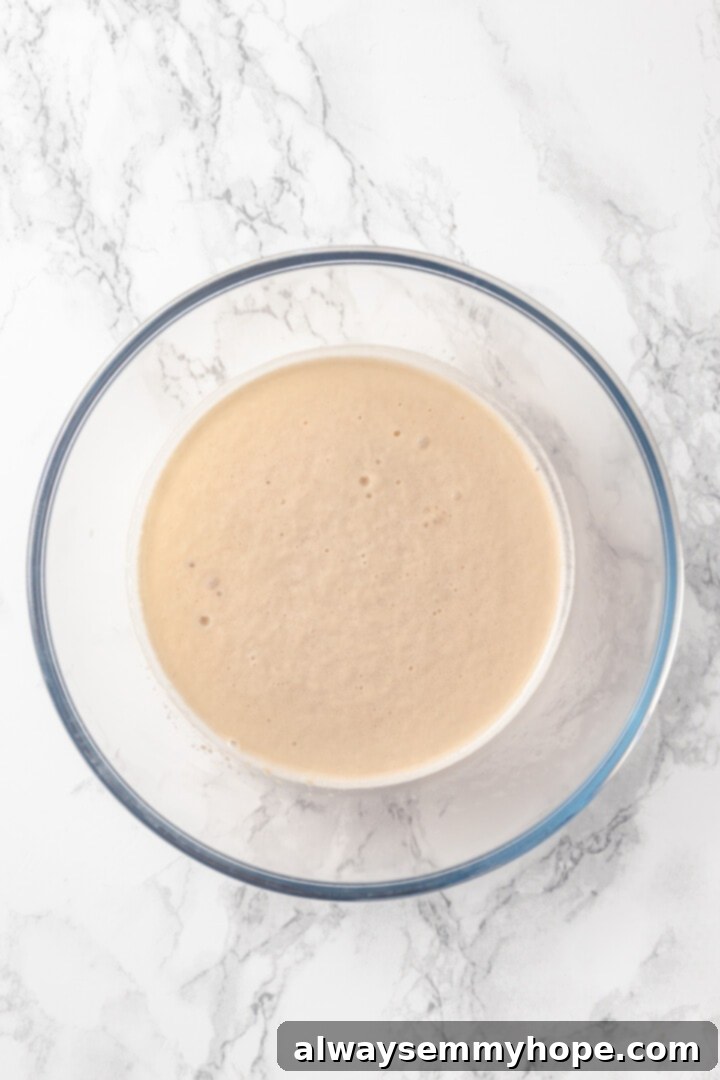 Homemade vegan pretzel bites are the snackable sibling to regular soft pretzels! They're perfect for game day parties and easy to make too. A mixing bowl with agave, yeast, and warm water, showing the early stages of yeast activation.