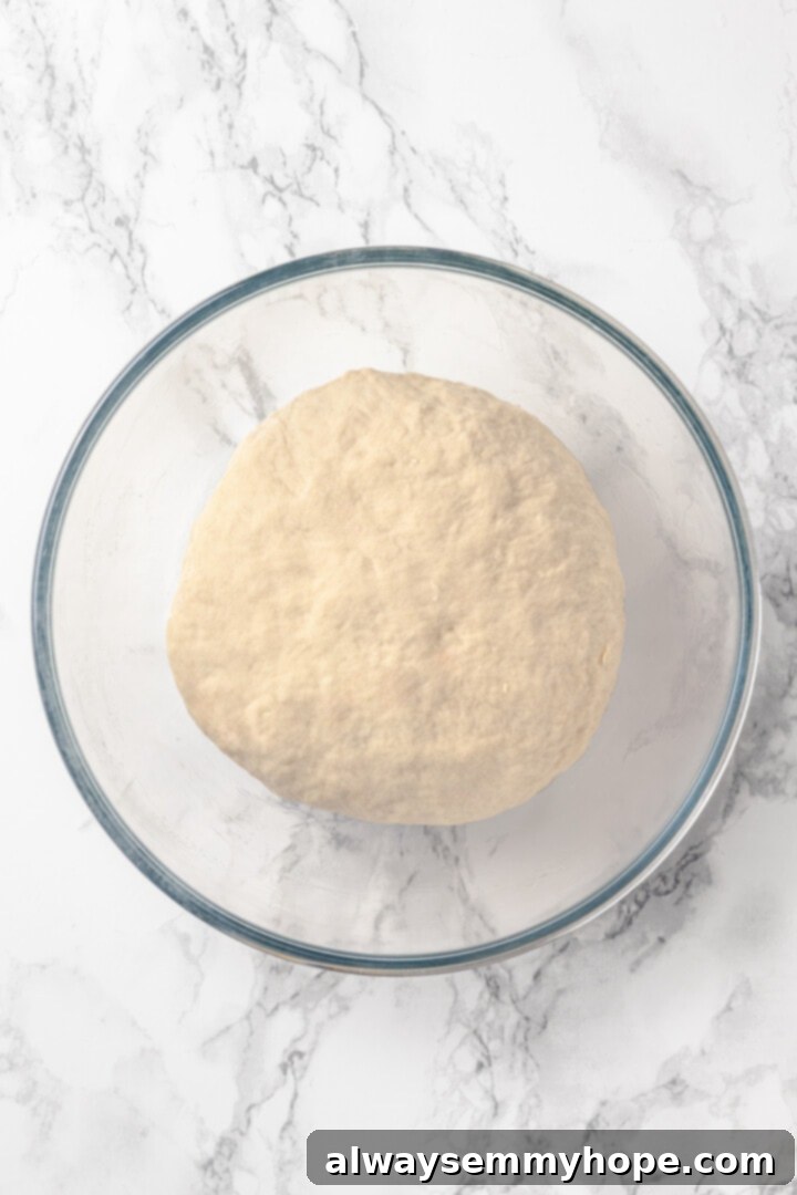 Homemade vegan pretzel bites are the snackable sibling to regular soft pretzels! They're perfect for game day parties and easy to make too. A smooth, round ball of pretzel dough resting in a bowl, perfectly kneaded and ready for its first rise.