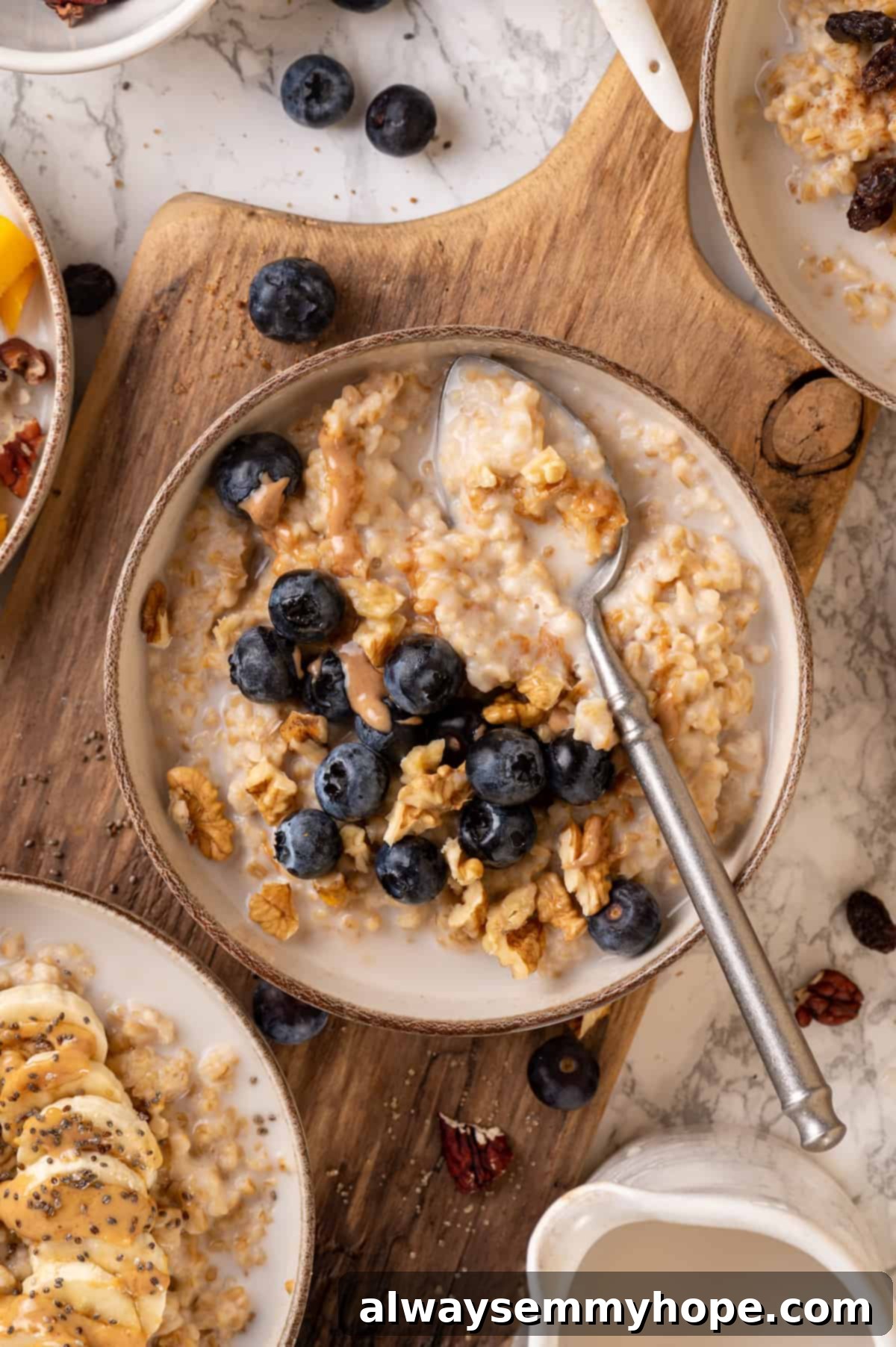 This Instant Pot steel-cut oats recipe is the easiest way to make hearty and creamy oatmeal for breakfast. Simple, hands-off recipe! Overhead view of blueberry Instant Pot steel-cut oats in bowl with spoon, garnished with fresh blueberries and almond butter drizzle