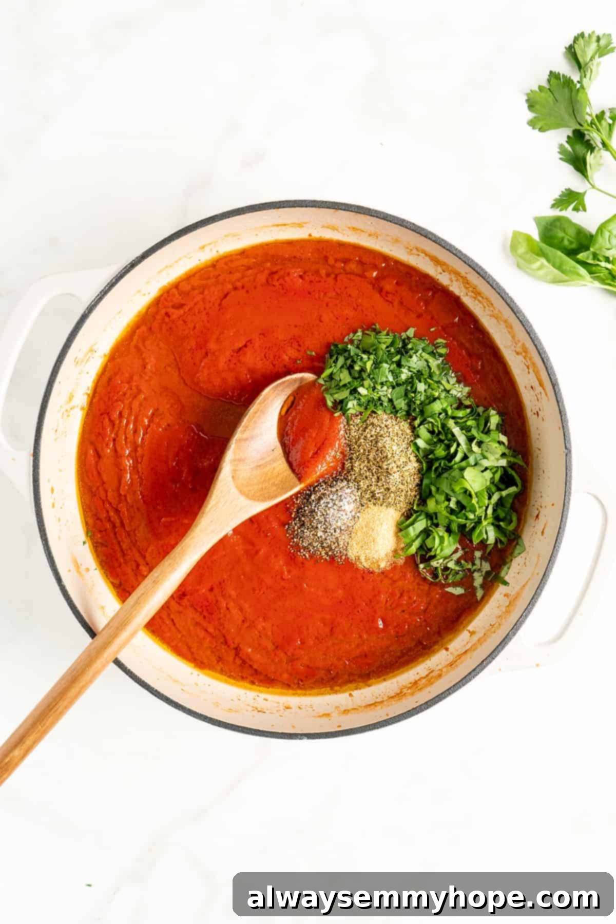 You won't believe how easy it is to make homemade marinara sauce! This recipe is ready to eat in 15 minutes. No peeling or chopping tomatoes! Overhead view of marinara sauce ingredients in a pot, with seasonings about to be stirred in.