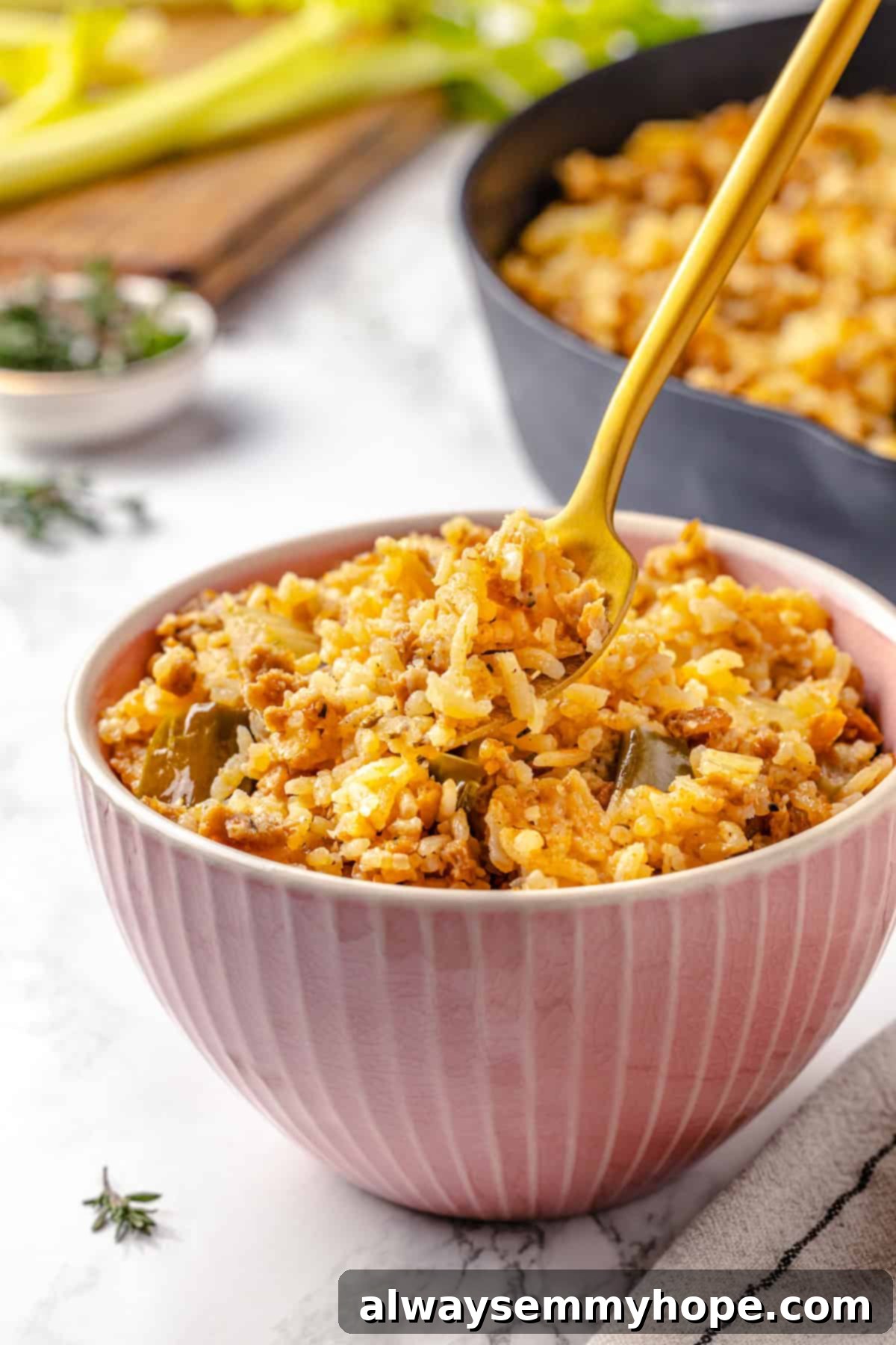 Forkful of vegan dirty rice held over a bowl, showcasing the textures and colors of the dish.