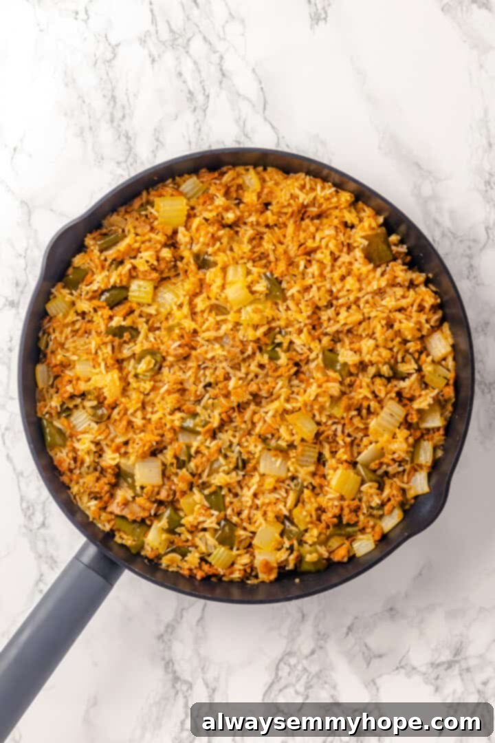Close-up overhead shot of perfectly cooked vegan dirty rice in a skillet, ready to be fluffed.