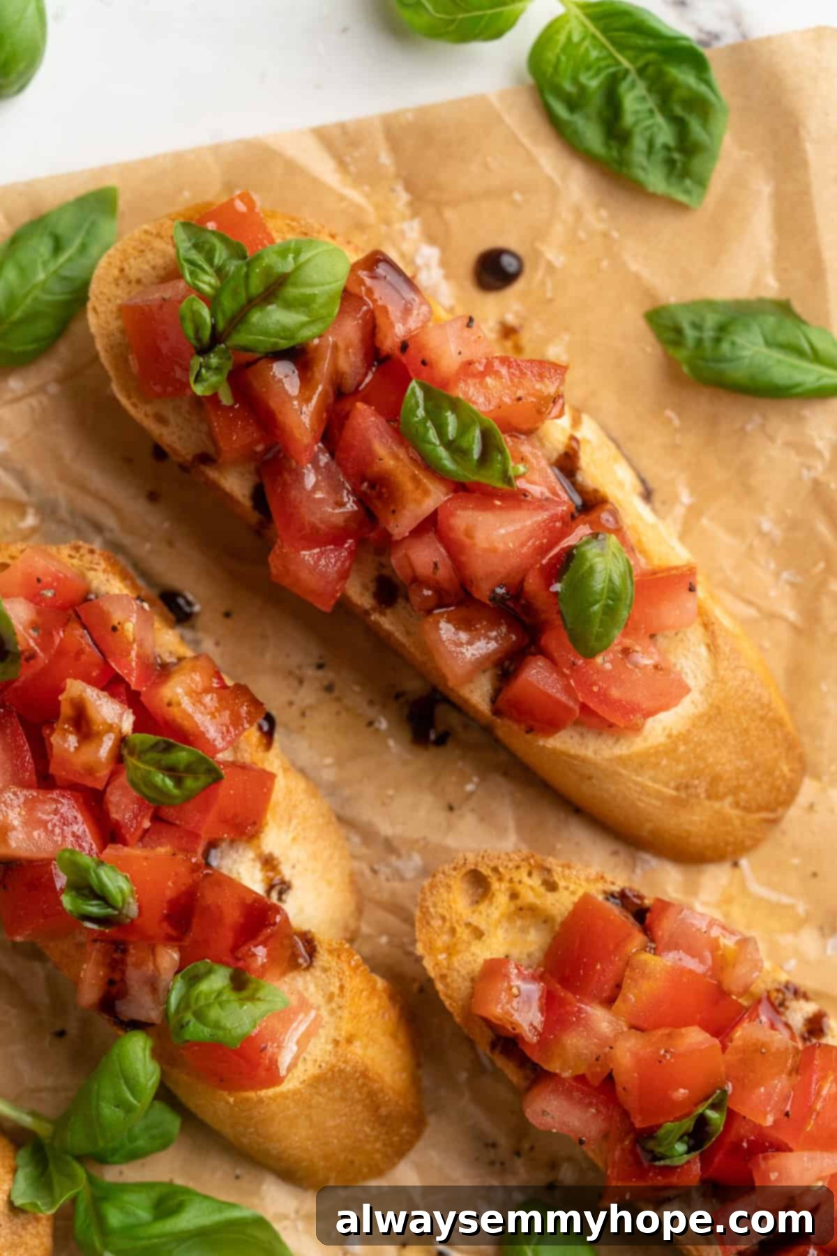Artfully arranged slices of classic bruschetta on parchment paper, ready to be served, showcasing the fresh tomatoes and balsamic glaze.