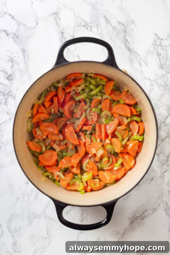 With kale, veggies, and lots of herbs and garlic, this easy gnocchi soup recipe is packed with flavour. It makes a hearty, satisfying meal! Softened diced onions, celery, and carrots sautéing in a Dutch oven