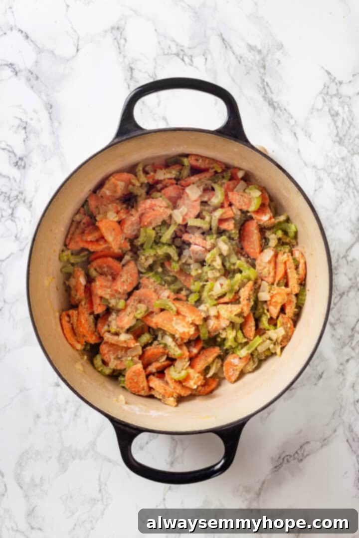 With kale, veggies, and lots of herbs and garlic, this easy gnocchi soup recipe is packed with flavour. It makes a hearty, satisfying meal! Overhead view of softened vegetables in a Dutch oven after flour has been stirred in, creating a roux