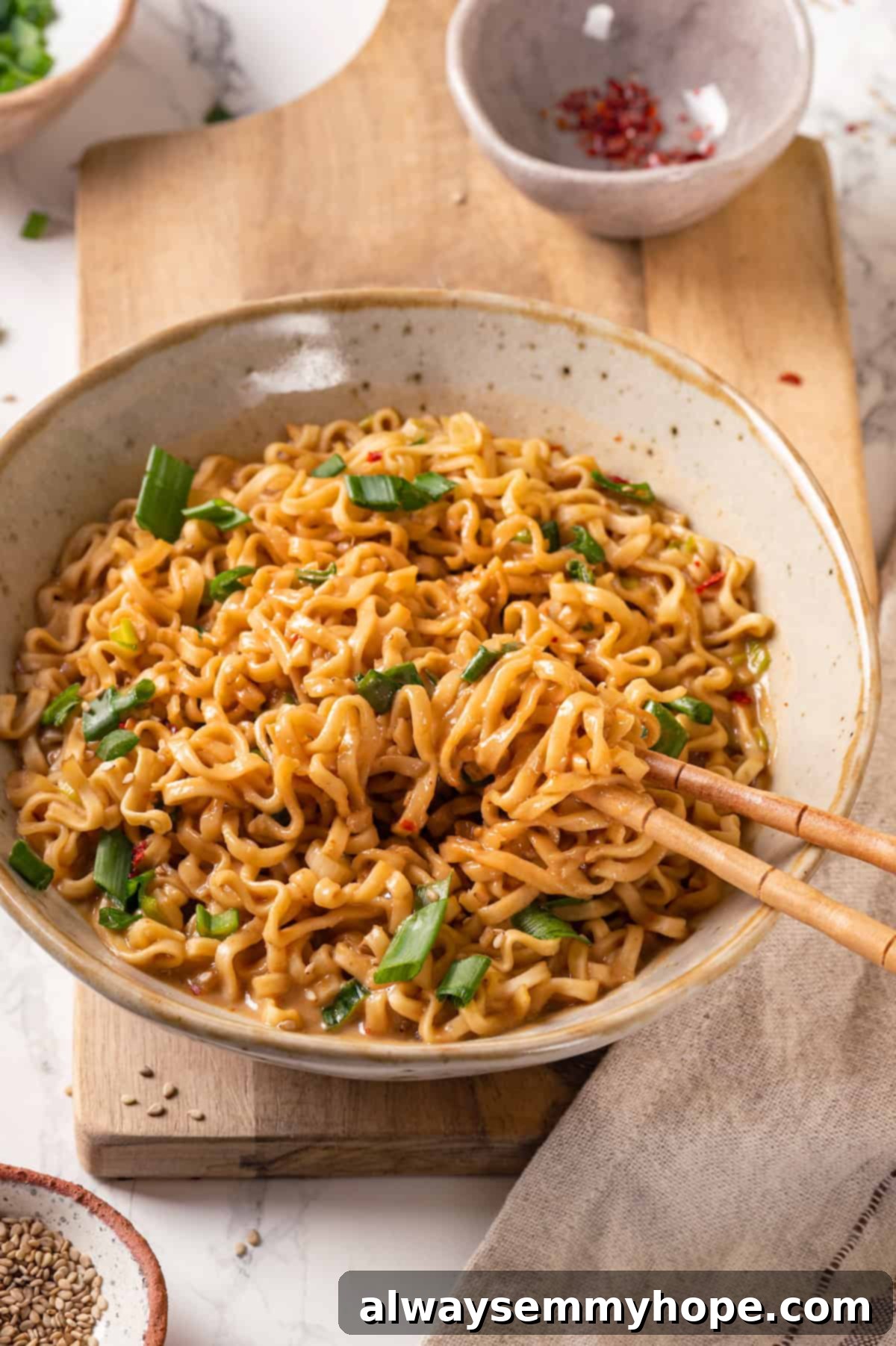 Peanut butter ramen in bowl with chopsticks, ready to eat, with a focus on the rich sauce.