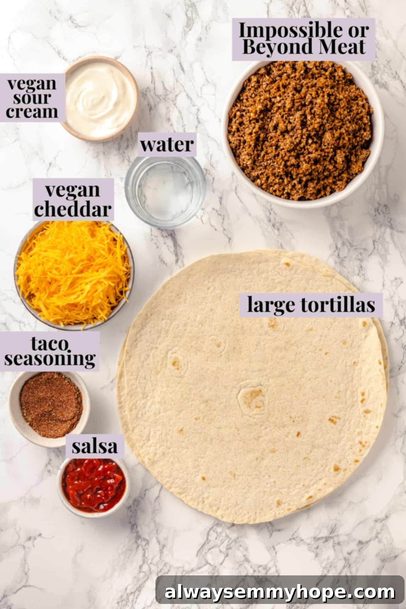 With layers of seasoned taco meat, plant-based cheese, and tortillas, this easy taco bake recipe is sure to please the whole family! Overhead shot showcasing a vibrant array of fresh ingredients laid out on a wooden surface, ready for assembly into the vegan taco bake.