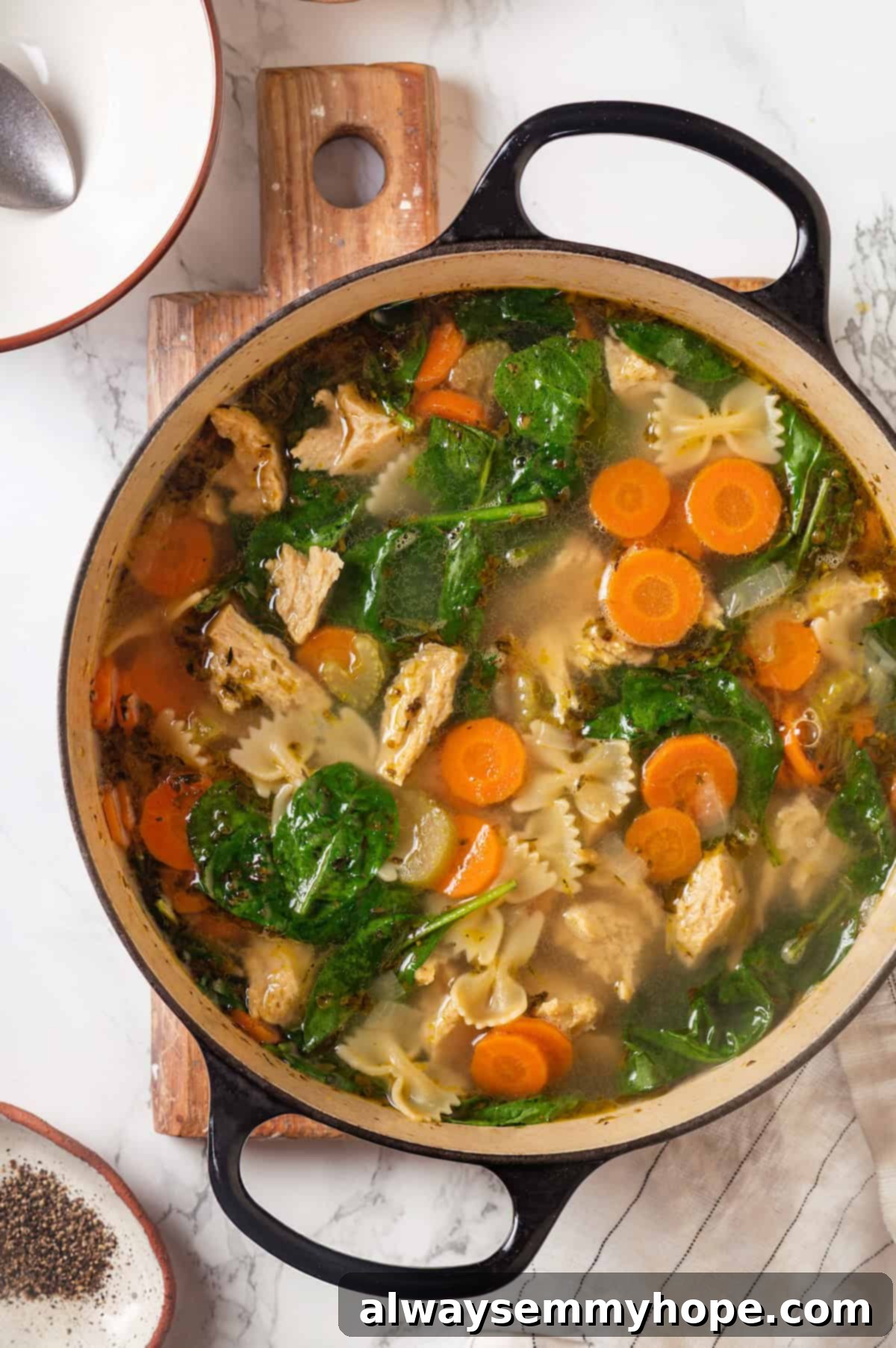 Overhead view of a large Dutch oven filled with homemade vegan chicken noodle soup, steaming hot and ready to serve.