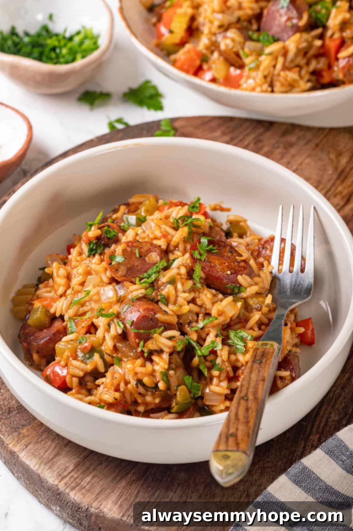 Vegan jambalaya recipe is comfort food Cajun style! With rice, veggies and plant-based sausage, this is a meal that’s flavourful and hearty. Bowl of vegan jambalaya with a fork, ready to be enjoyed