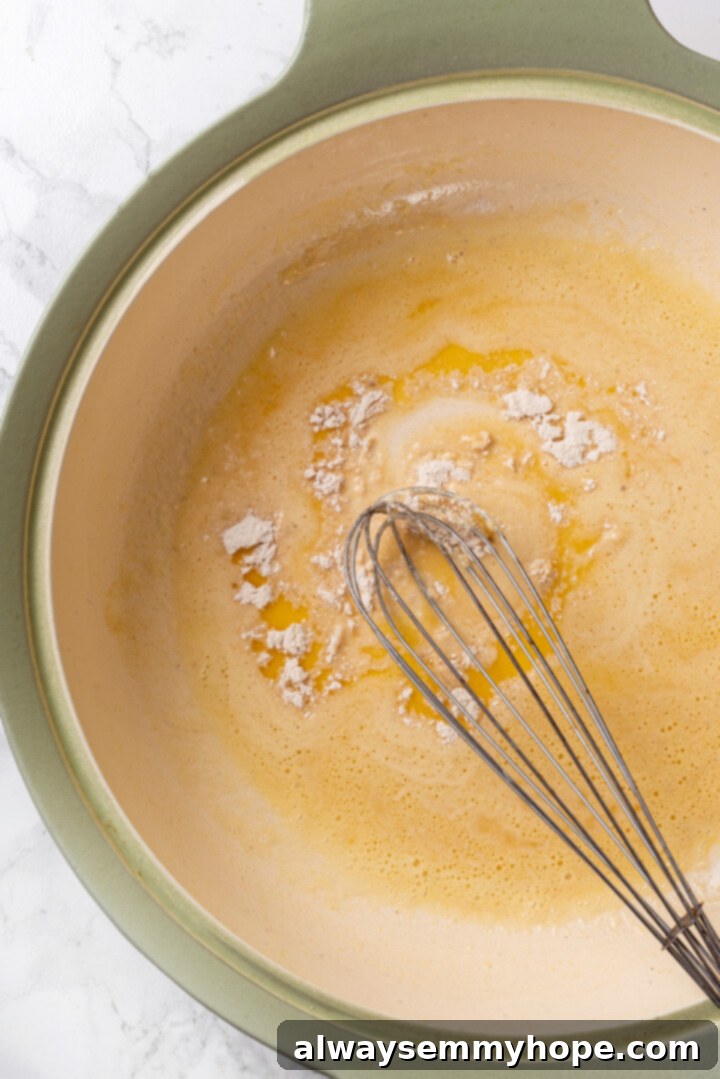 Vegan jambalaya recipe is comfort food Cajun style! With rice, veggies and plant-based sausage, this is a meal that’s flavourful and hearty. Overhead view of whisk mixing flour into melted butter in a skillet for a roux