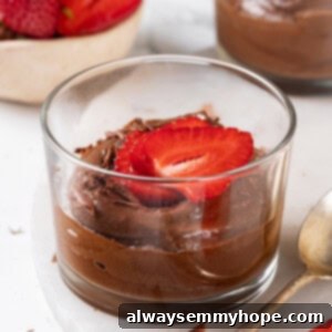 Decadent Avocado Chocolate Mousse 2 Vegan chocolate avocado mousse served in two glass ramekins, garnished with fresh berries.