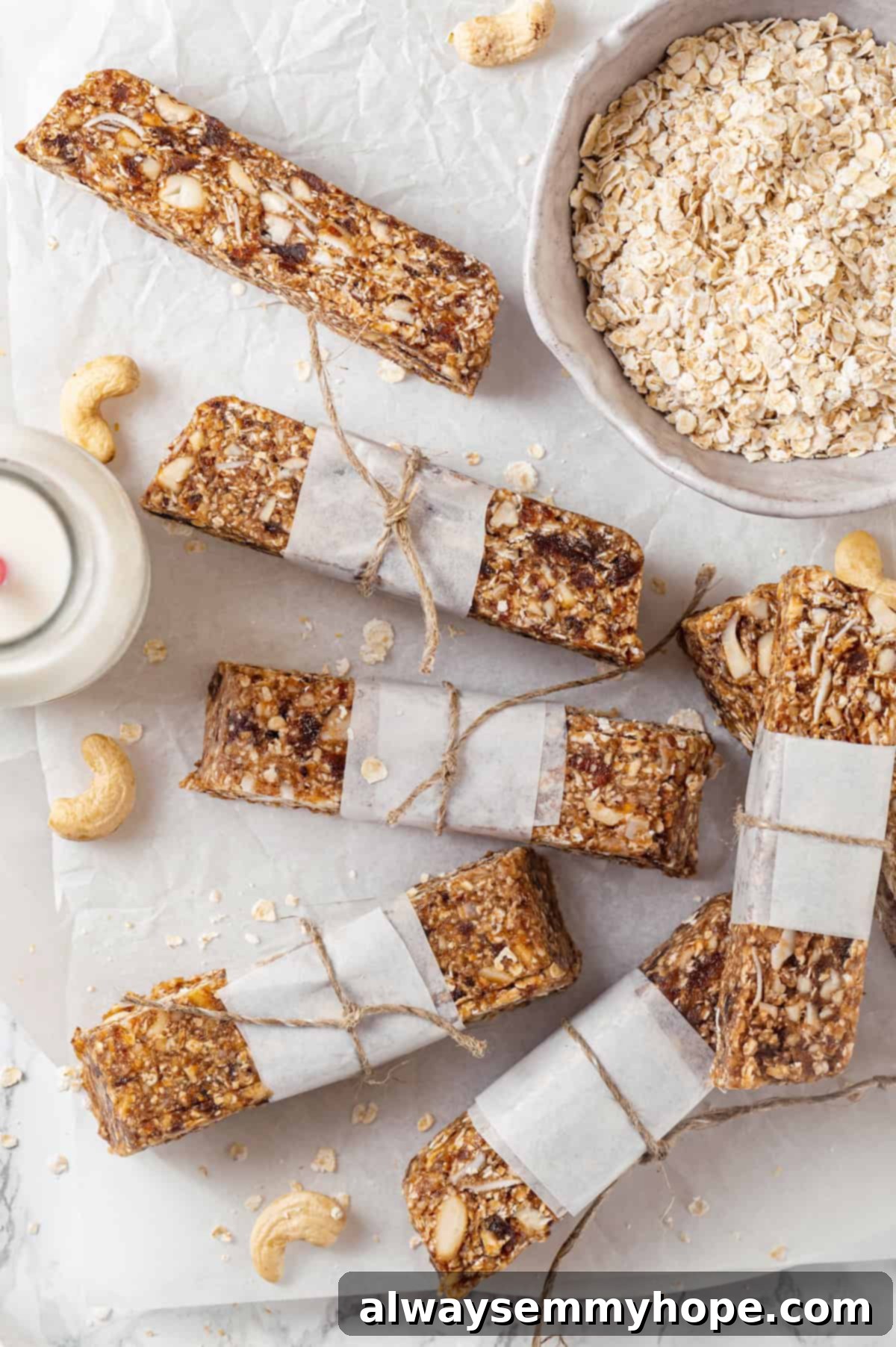 Overhead view of homemade granola bars on countertop with bowl of oats