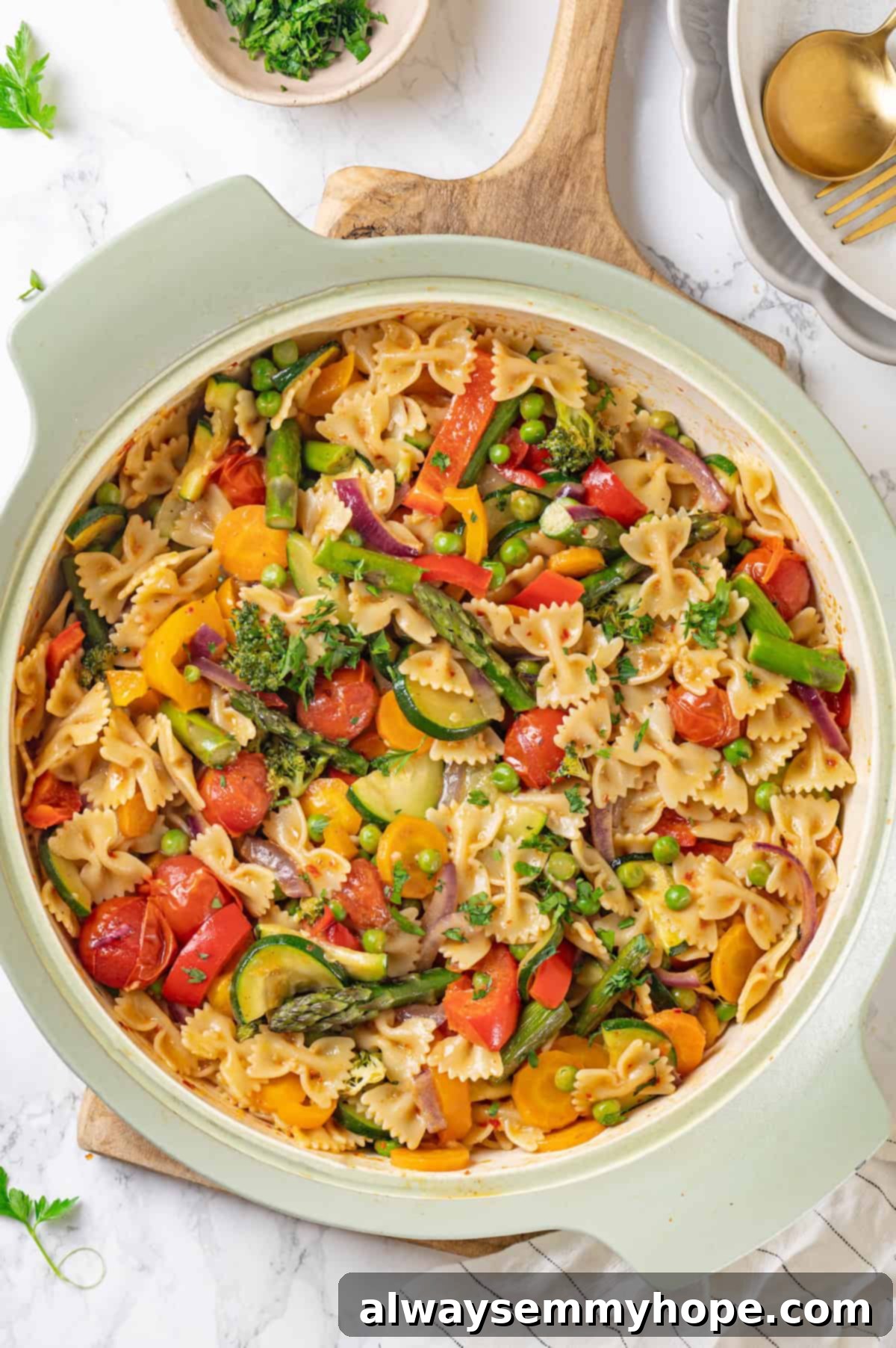 Overhead view of a large skillet filled with vegan pasta primavera, ready to be served