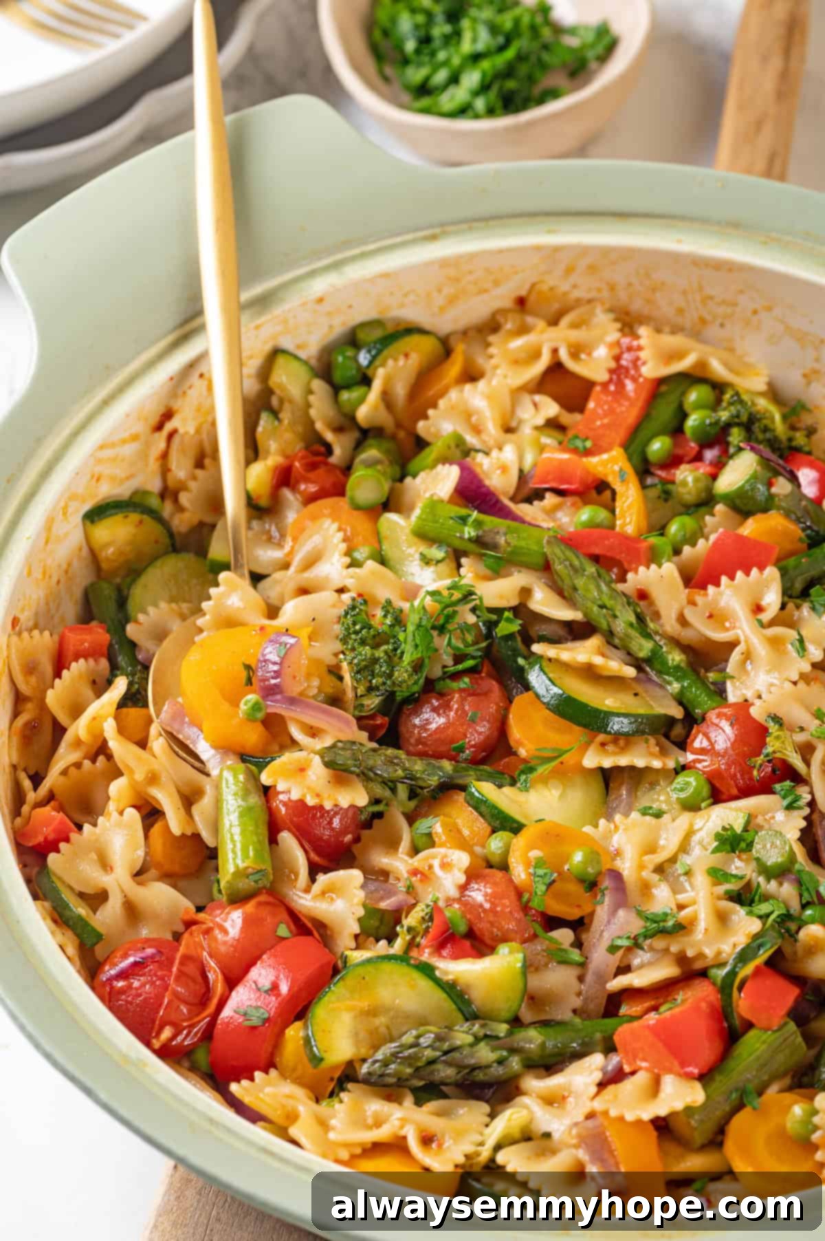 Close-up view of vegan pasta primavera in a skillet, showcasing the roasted vegetables and creamy sauce