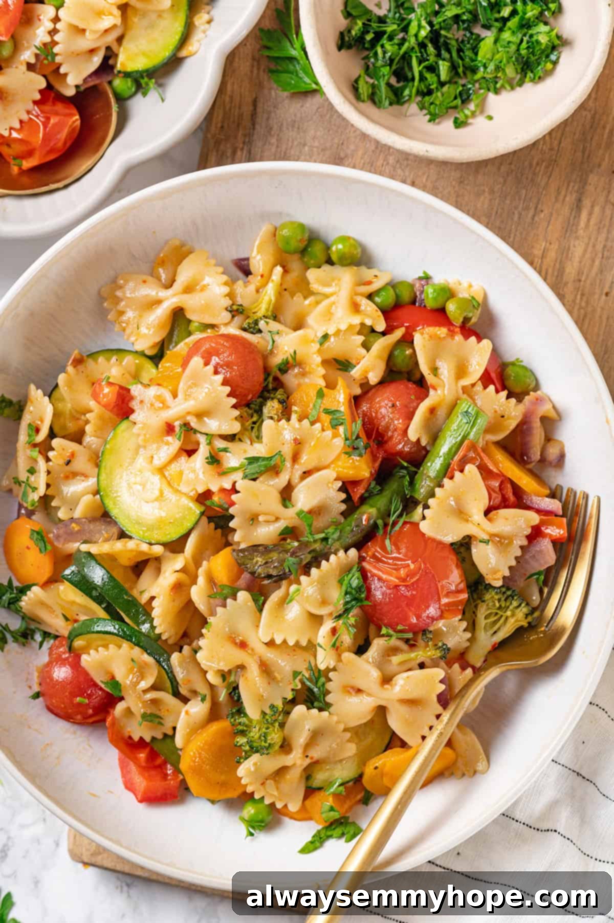 Overhead view of a bowl of vegan pasta primavera with a fork, ready to be enjoyed