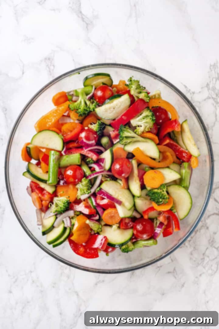 Overhead view of chopped vegetables in a large glass bowl