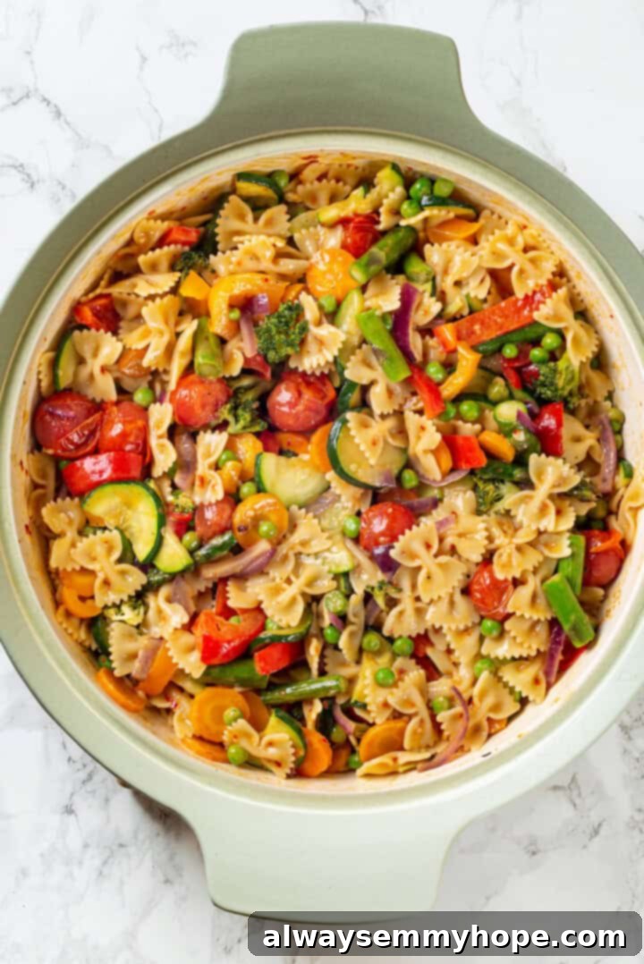 Overhead view of finished vegan pasta primavera in a skillet, ready to serve