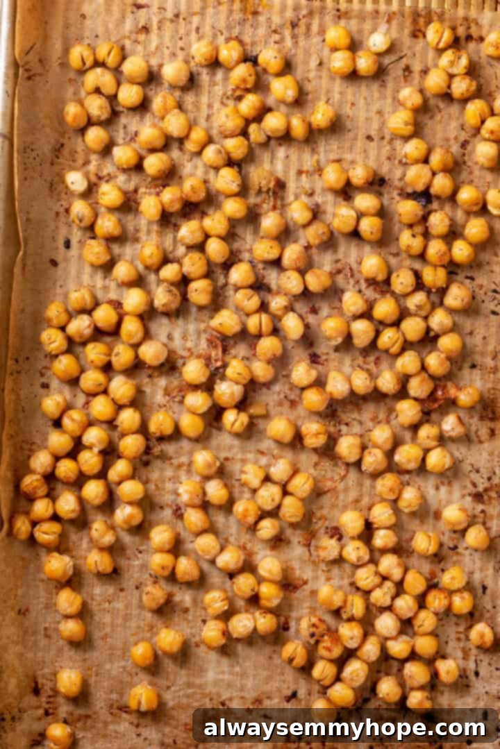 Overhead view of roasted chickpeas on parchment-lined pan
