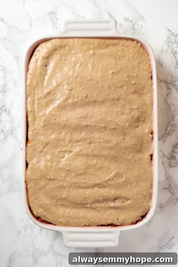 This vegan moussaka recipe has all the flavour of the classic Greek eggplant dish, but with tender lentils and mushrooms replacing the meat! Overhead view of vegan moussaka before baking