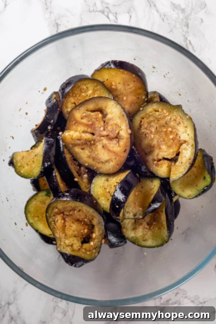 This vegan moussaka recipe has all the flavour of the classic Greek eggplant dish, but with tender lentils and mushrooms replacing the meat! Overhead view of eggplant slices in bowl