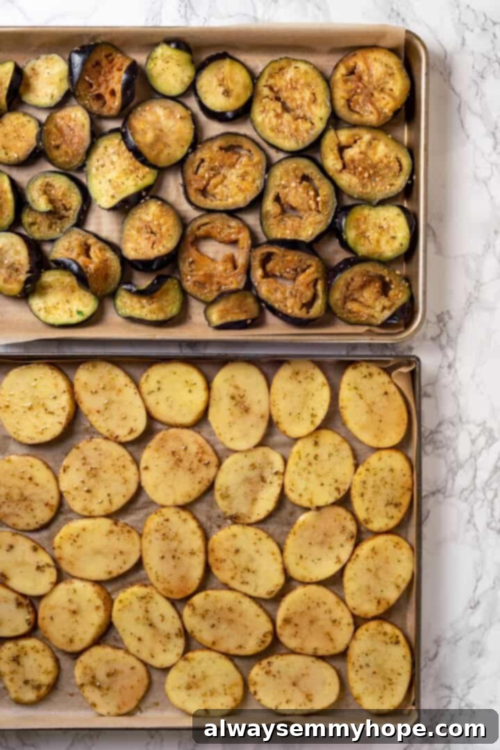 This vegan moussaka recipe has all the flavour of the classic Greek eggplant dish, but with tender lentils and mushrooms replacing the meat! Overhead view of seasoned eggplant and potato slices on pans