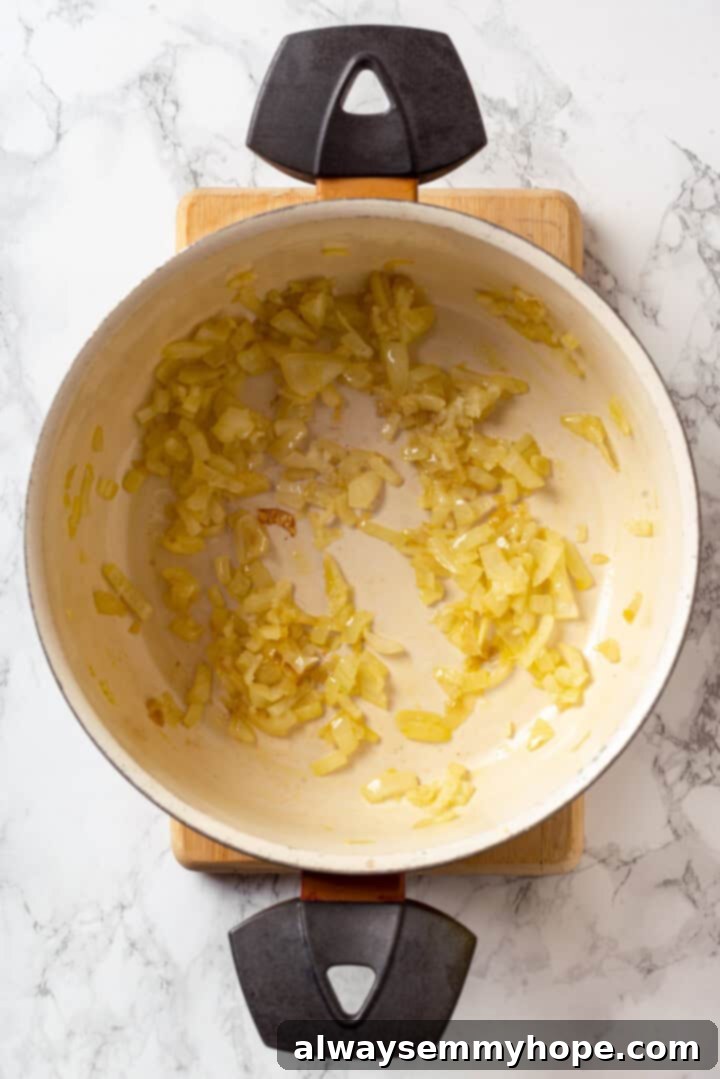 This vegan moussaka recipe has all the flavour of the classic Greek eggplant dish, but with tender lentils and mushrooms replacing the meat! Overhead view of onions and garlic in pan