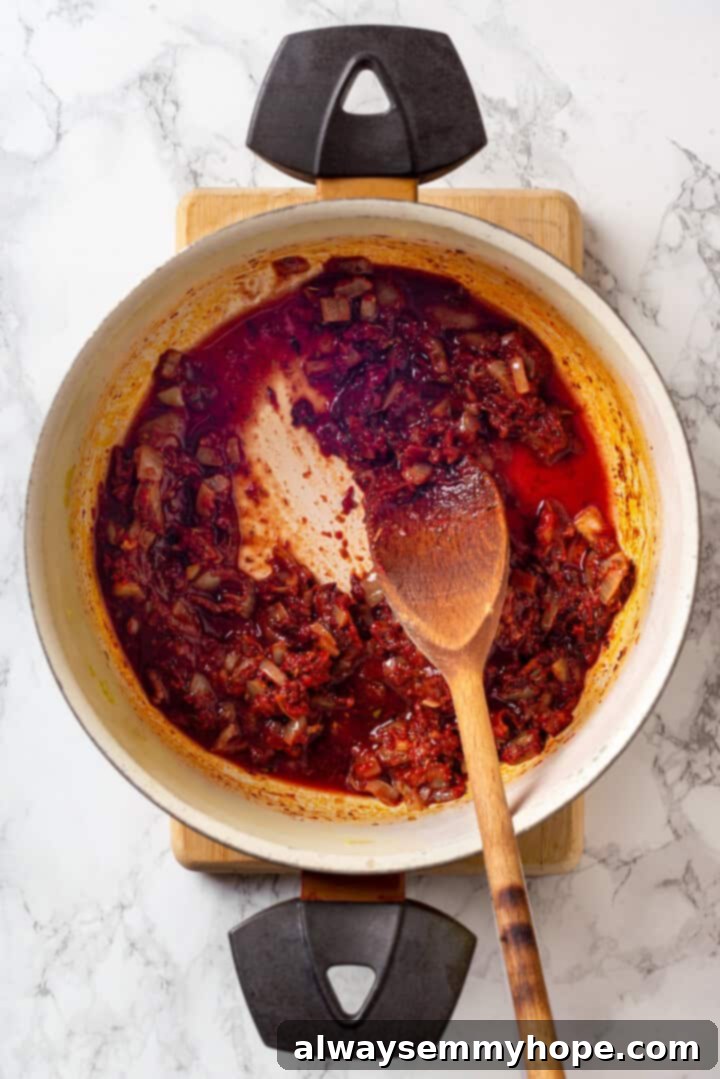 This vegan moussaka recipe has all the flavour of the classic Greek eggplant dish, but with tender lentils and mushrooms replacing the meat! Overhead view of wine deglazing pan