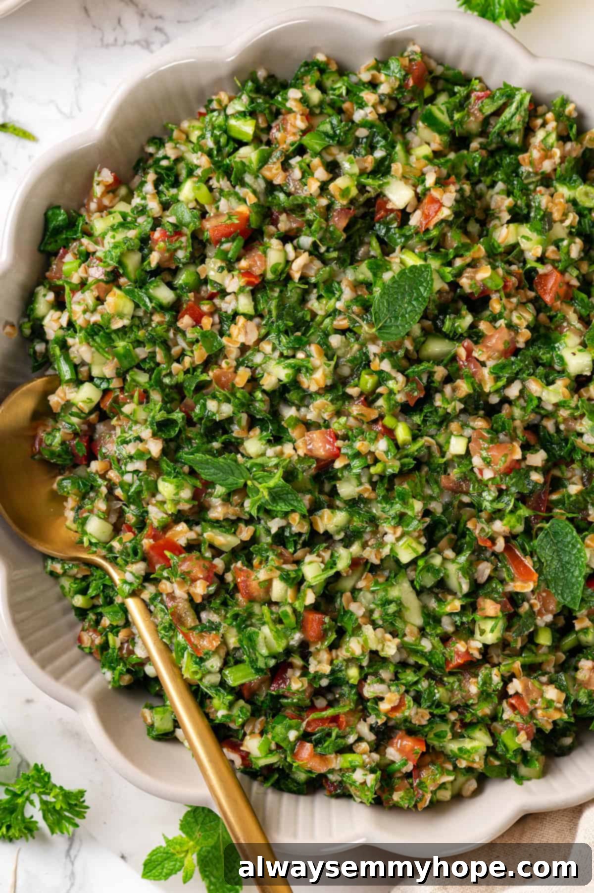 Overhead view of tabbouleh in a serving bowl with a spoon, highlighting its fresh ingredients and vibrant colors