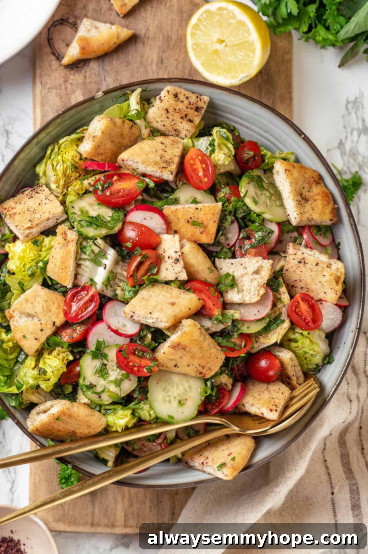 A large, vibrant Fattoush salad in a decorative bowl, garnished with fresh herbs, ready for serving. Overhead view of a beautifully presented fattoush salad in a large serving bowl with a spoon and fork