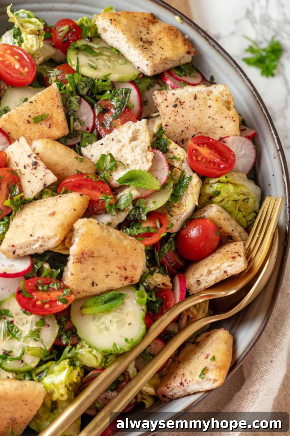 A close-up of a bowl of Fattoush salad with a serving spoon and fork, highlighting the vibrant colors and textures. Bowl of fattoush salad with a serving spoon and fork, showcasing its freshness