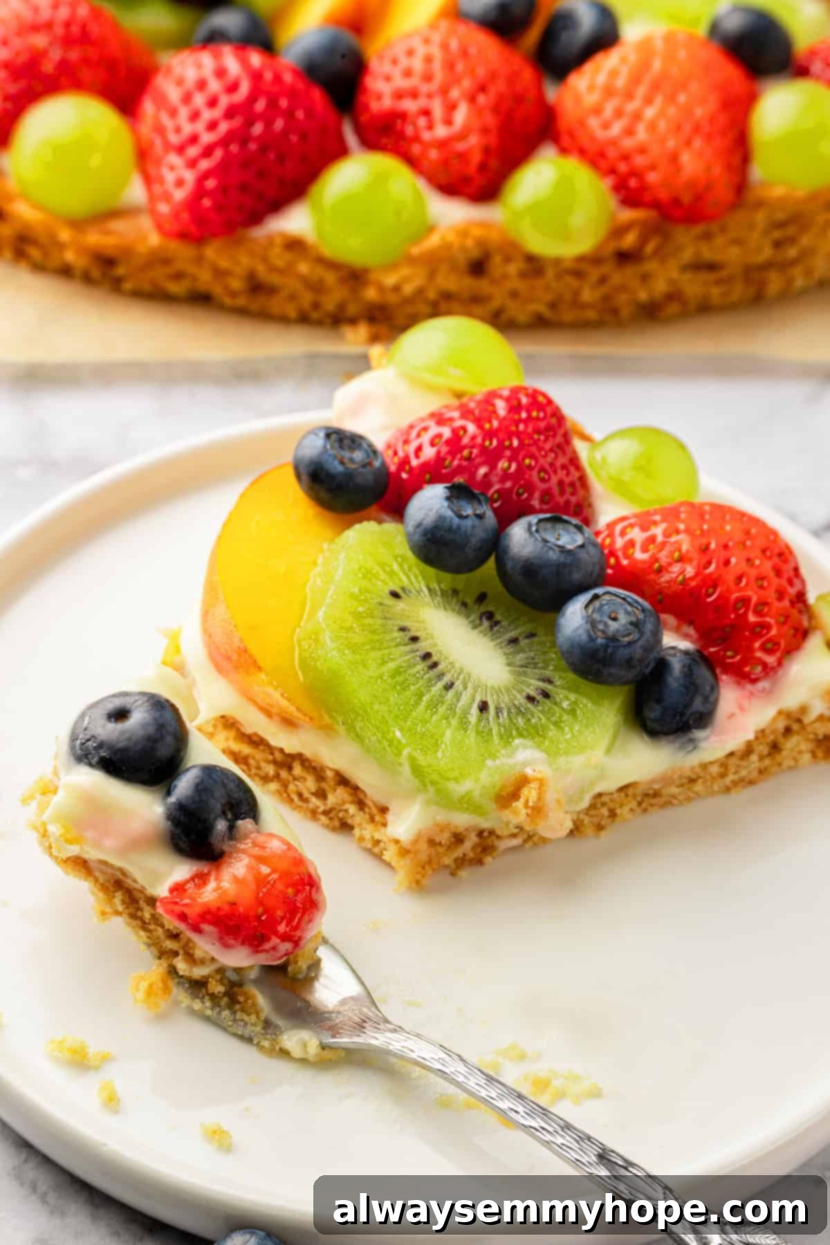 Slice of fruit pizza on plate cut into pieces
