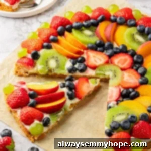 Cut fruit pizza with one slice pulled away