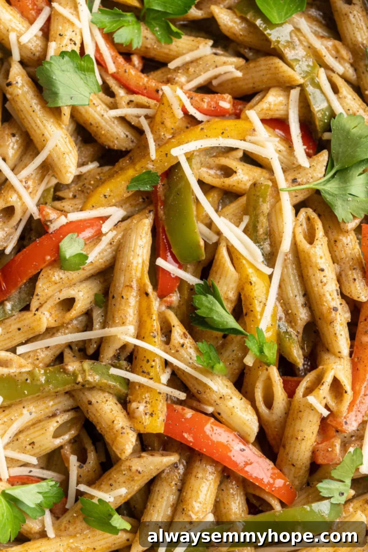Overhead close-up of a serving of vegan Rasta Pasta, garnished with fresh herbs, showcasing its vibrant colors and creamy texture.